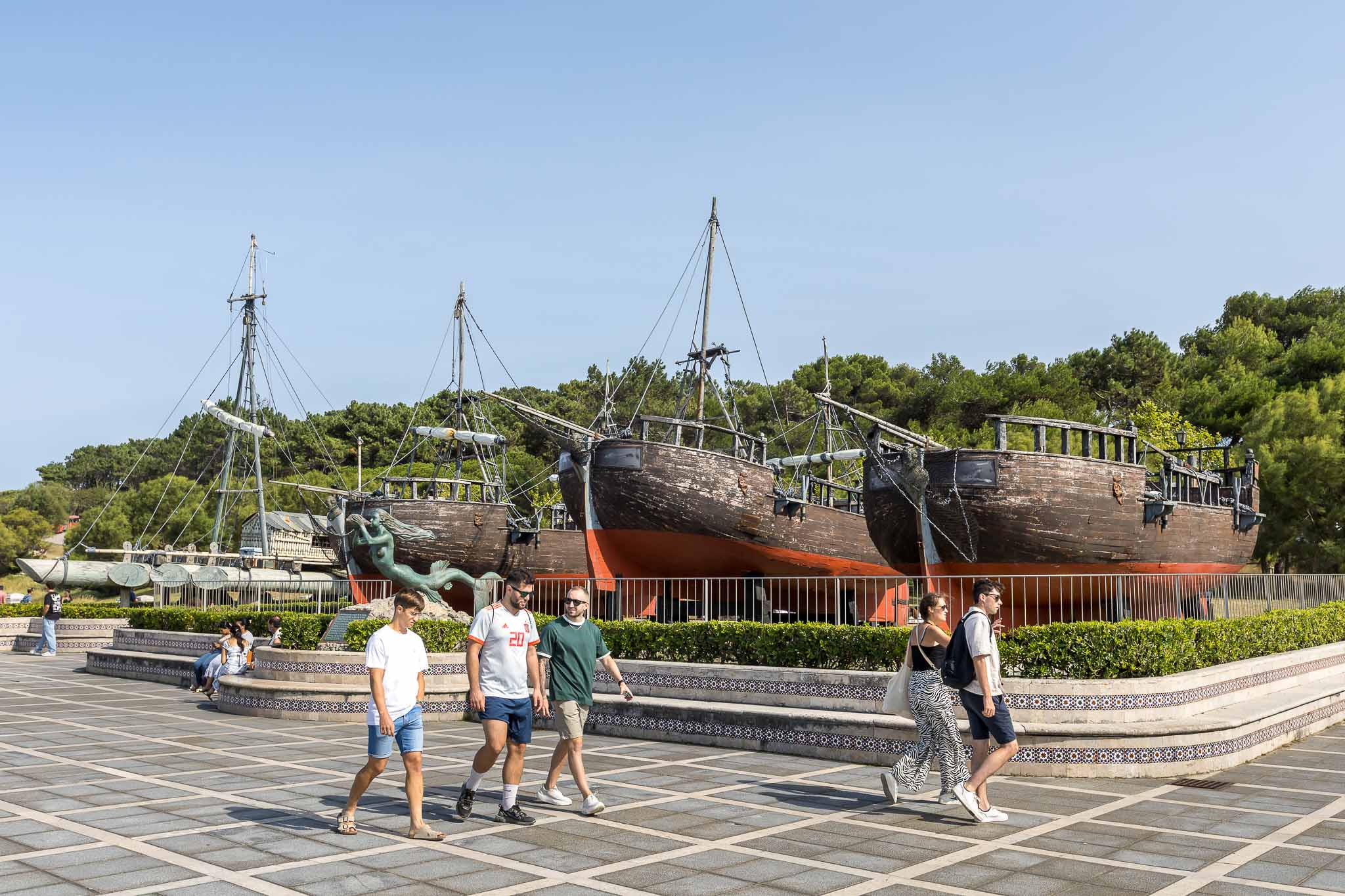 Un grupo de visitantes pasa junto a los tres galeones, que están vallados para evitar la entrada de la gente.