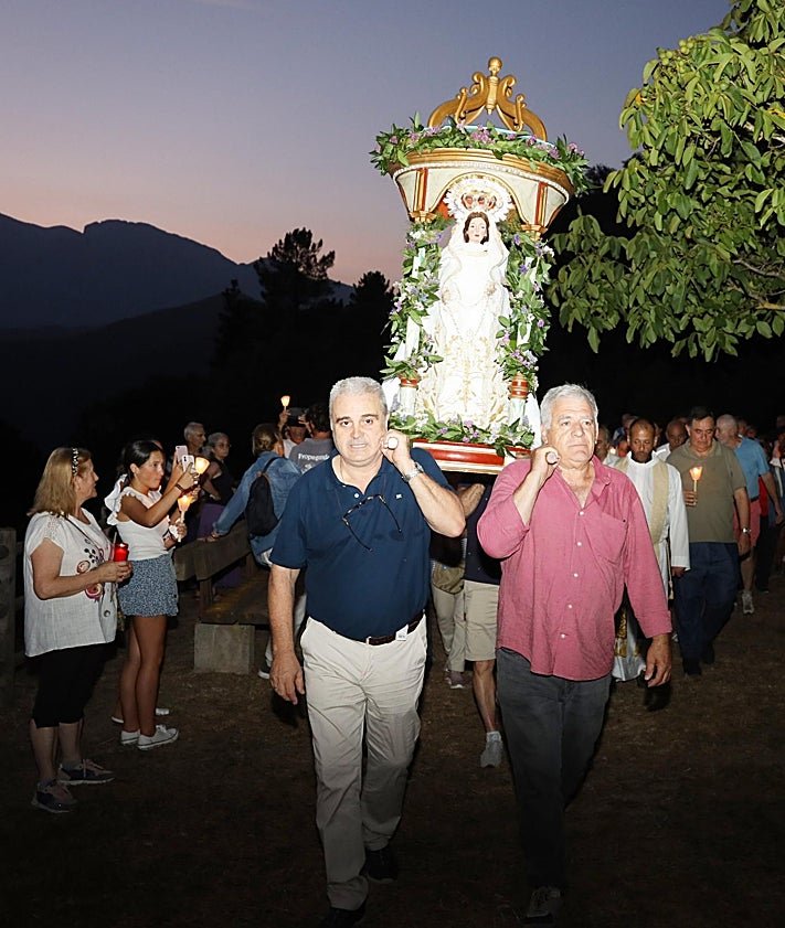 Imagen secundaria 2 - Personas de todas las edades acompañaron a la patrona de Potes. A la izquierda, dos devotas llevan a la Virgen por la calle Cántabra y , a la derecha, dos devotos la llevan en las andas a la salida de su santuario
