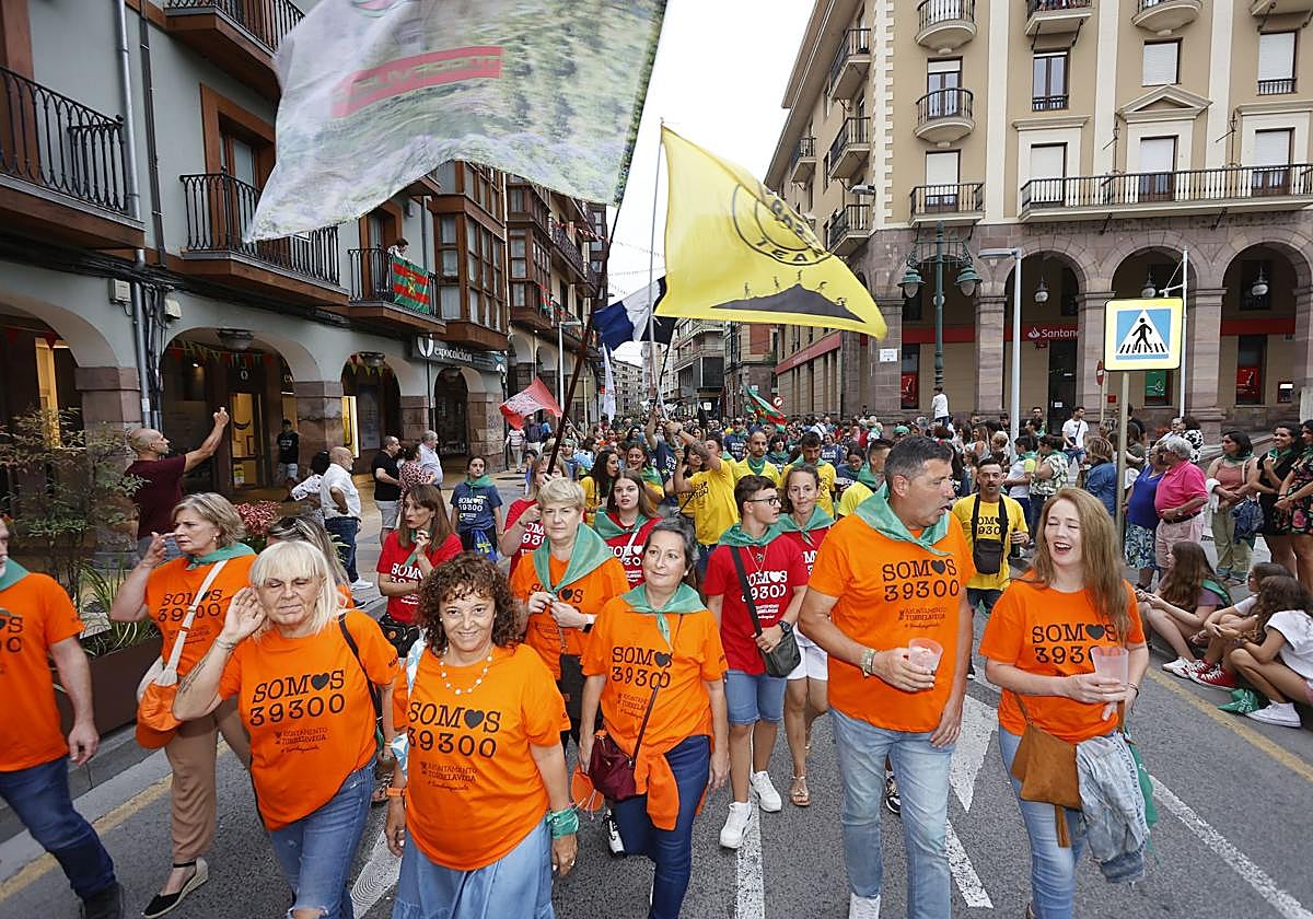 Peñistas marchan durante el desfile inaugural de las fiestas, por la calle José María Pereda de Torrelavega.