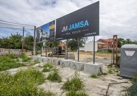 El cartel que anuncia la promoción de las 12 viviendas y la maquinaria que ya trabaja en dar forma al proyecto.