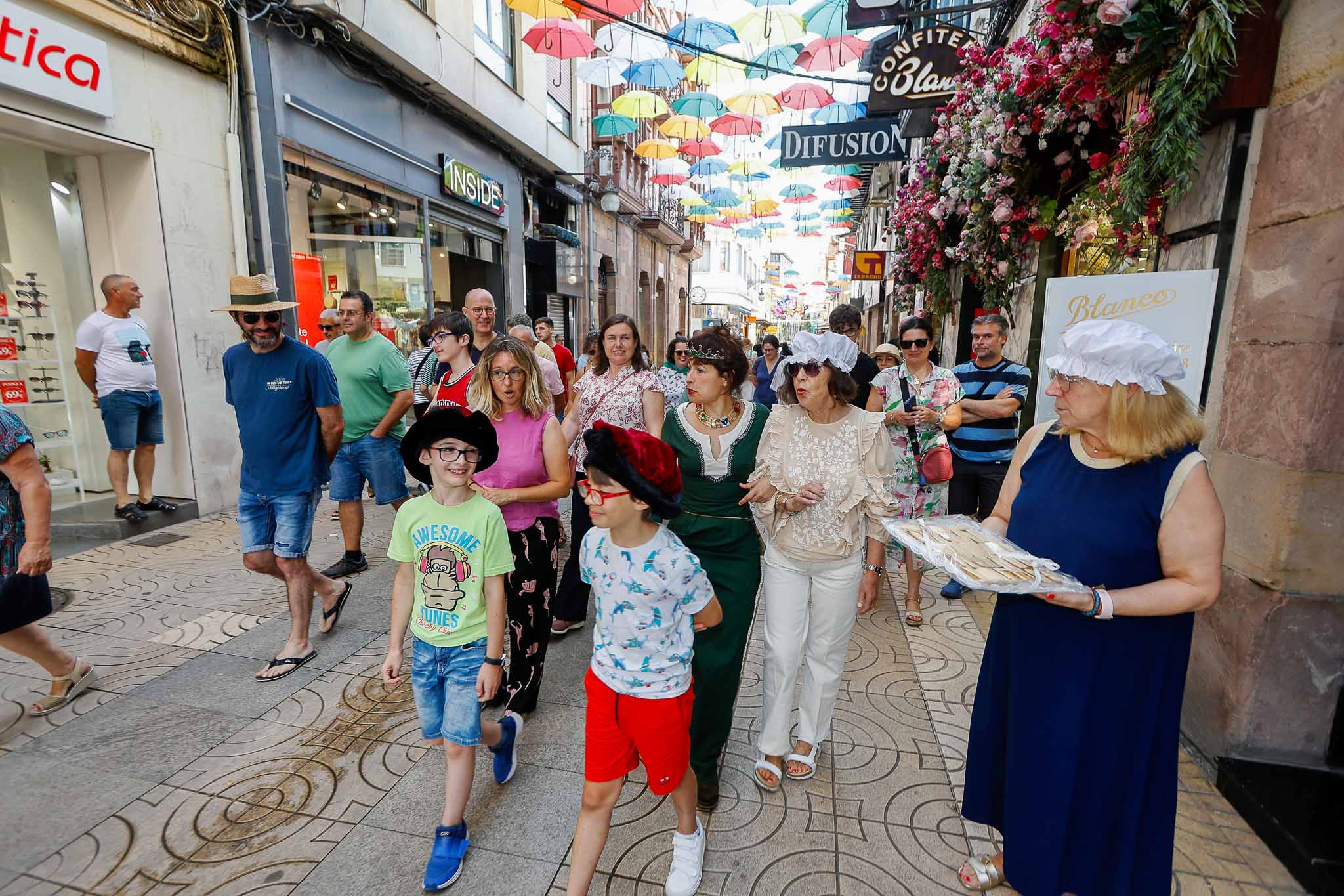 El paseo cruza las sombrillas multicolor en la calle Consolación.