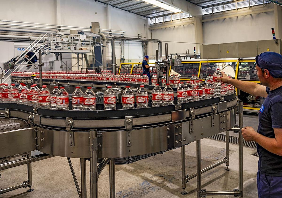Operarios junto a una de las nuevas líneas de embotellado que ya están operativas en la planta de Agua de Solares.