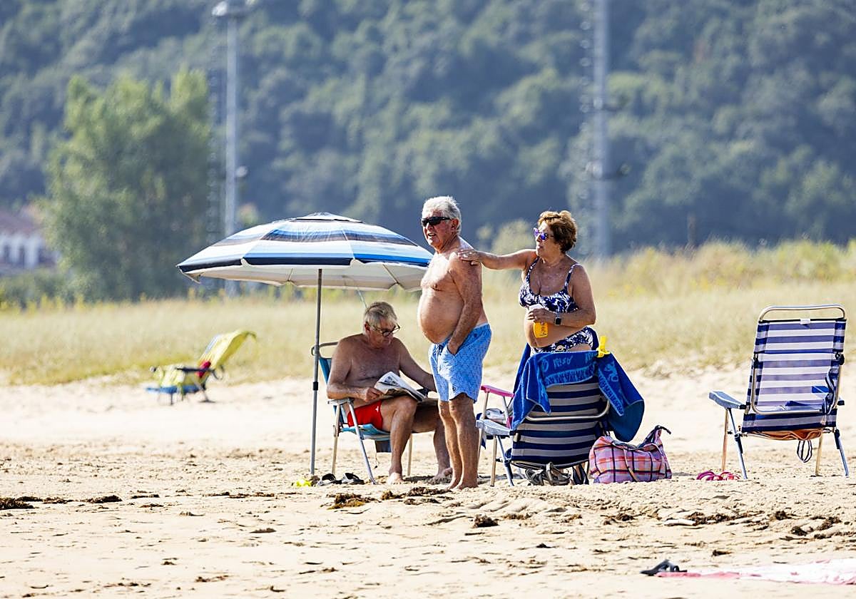 Una mujer da crema protector solar a un hombre esta mañana en Cantabria.