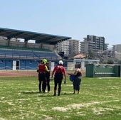 El niño en el campo de fútbol de Laredo, junto a los efectivos que participaron en el dispotivo.