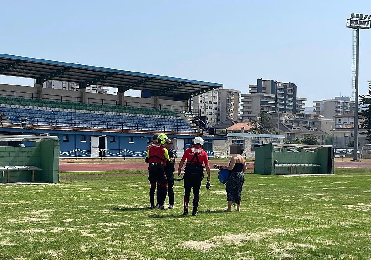 El niño en el campo de fútbol de Laredo, junto a los efectivos que participaron en el dispotivo.
