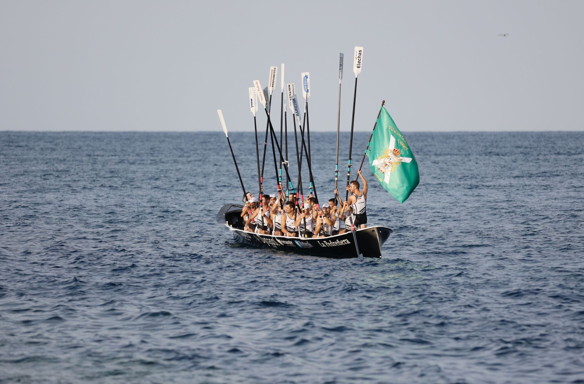 Traineras en Castro con los remos en alto