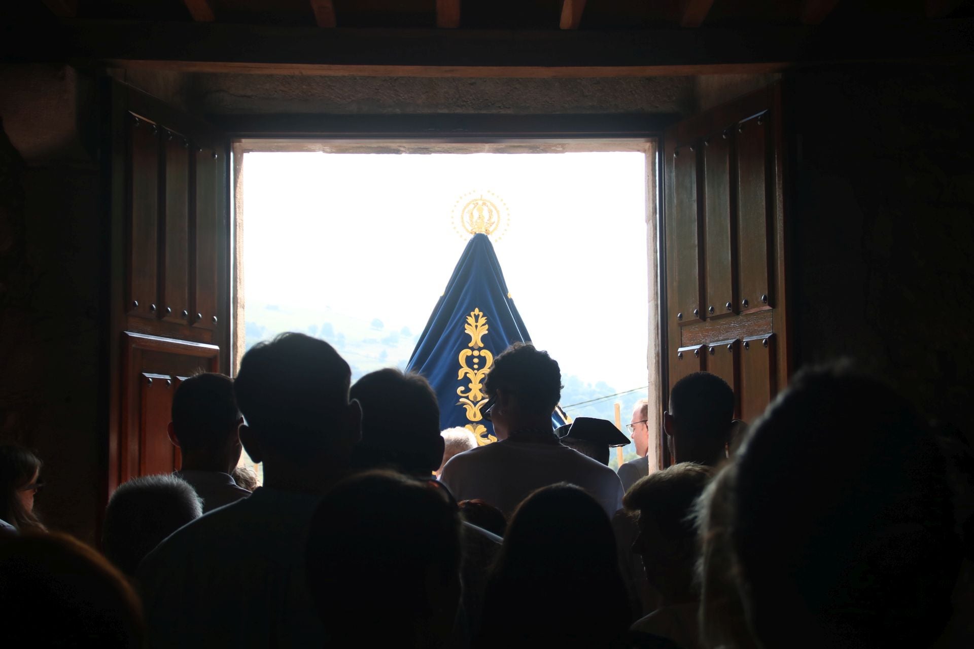 Salida de la virgen con sus devotos tras ella.