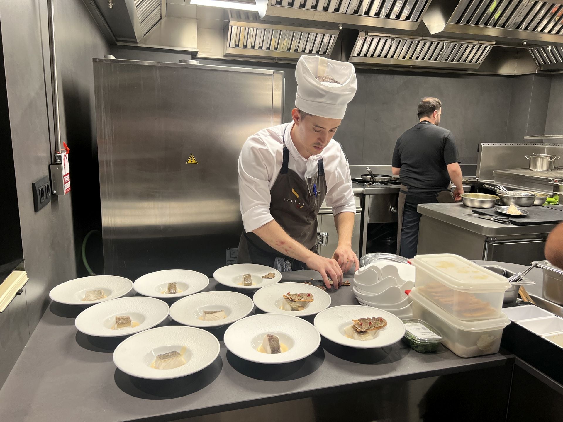 Lucas prepara varios platos del pescado del menú degustación.