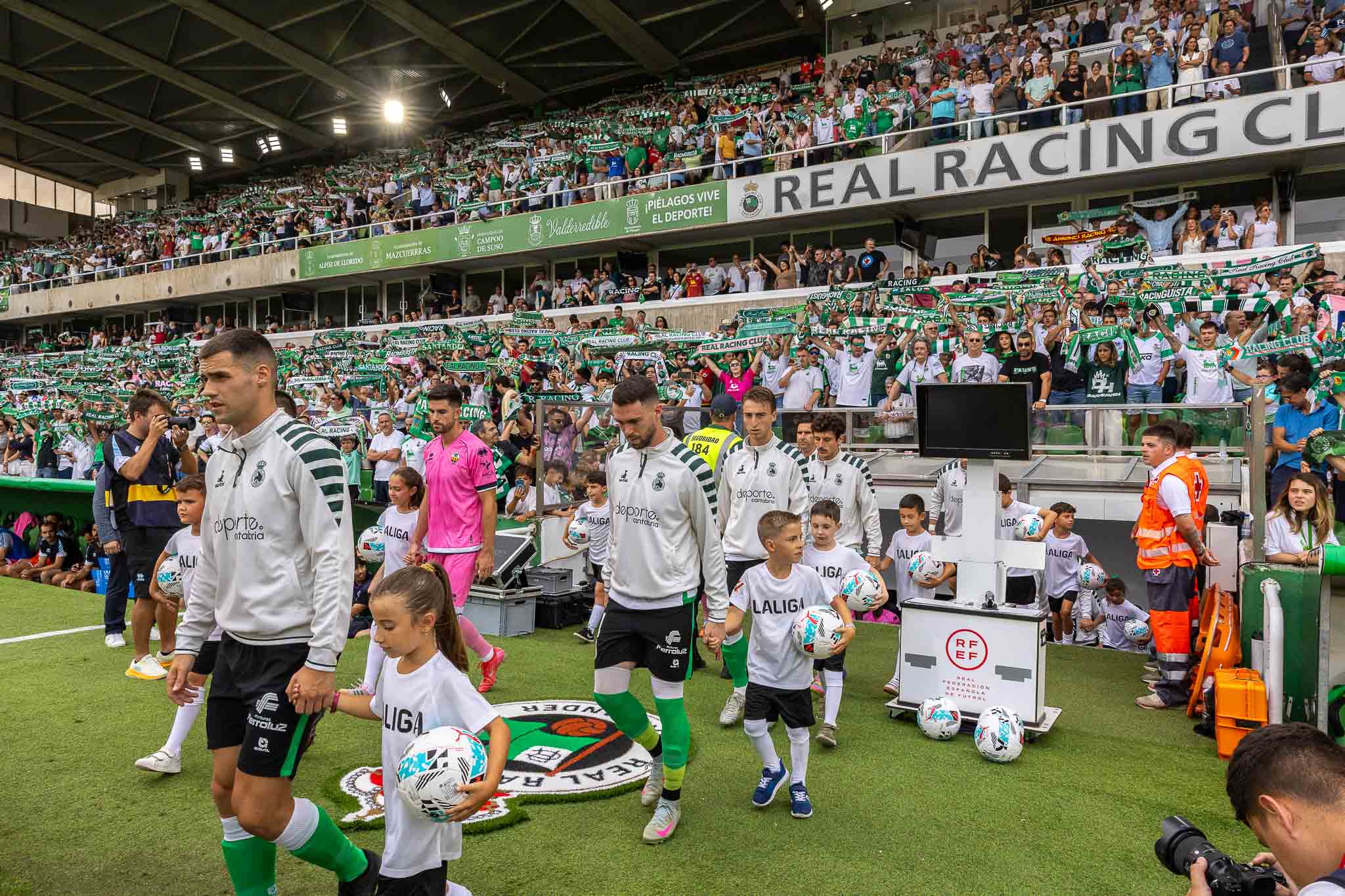 Los jugadores de ambos equipos saltan al terreno de juego. 