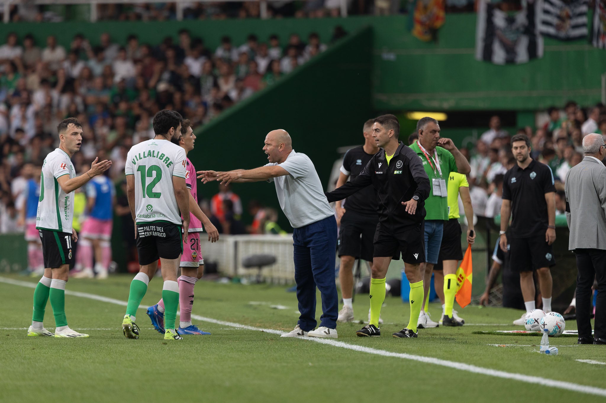 José Alberto llama a la calma a sus futbolistas mientras Dámaso Arcediano revisa en la pantalla el penalti sobre Villalibre. 