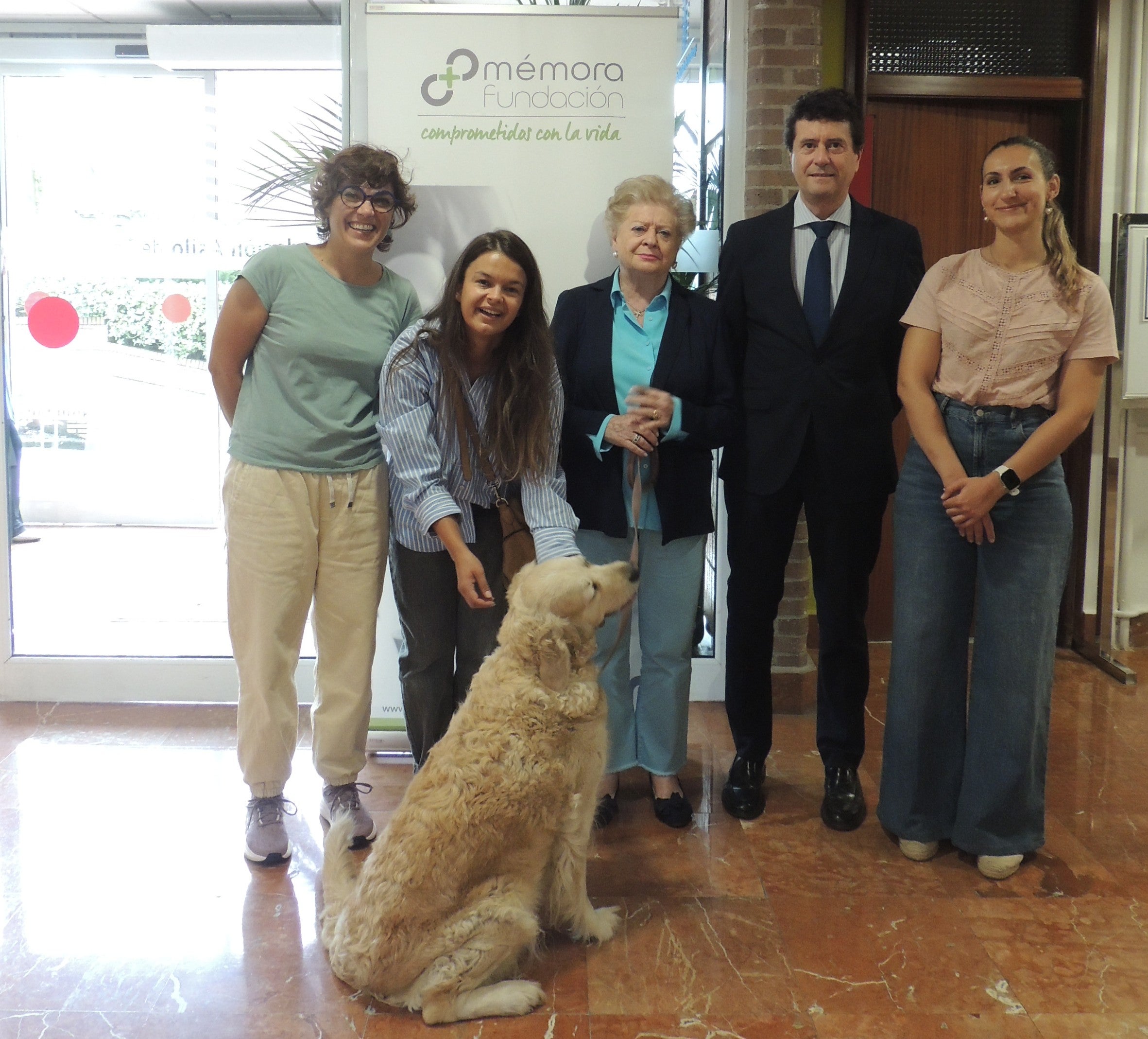 Miembros de la Fundación Asilo y la Fundación Mémora junto a uno de los perros de las terapias.
