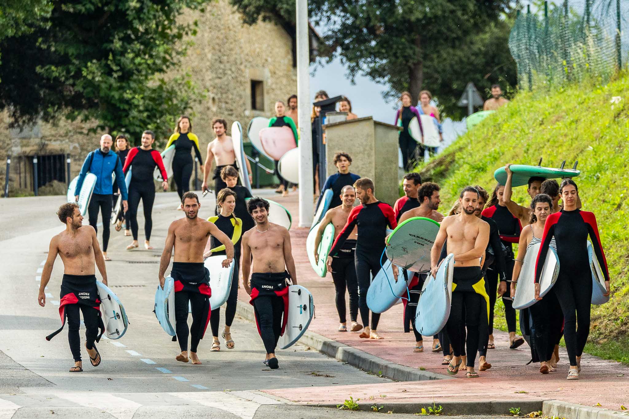 Alumnos de camino a la playa de Somo con las tablas en mano.