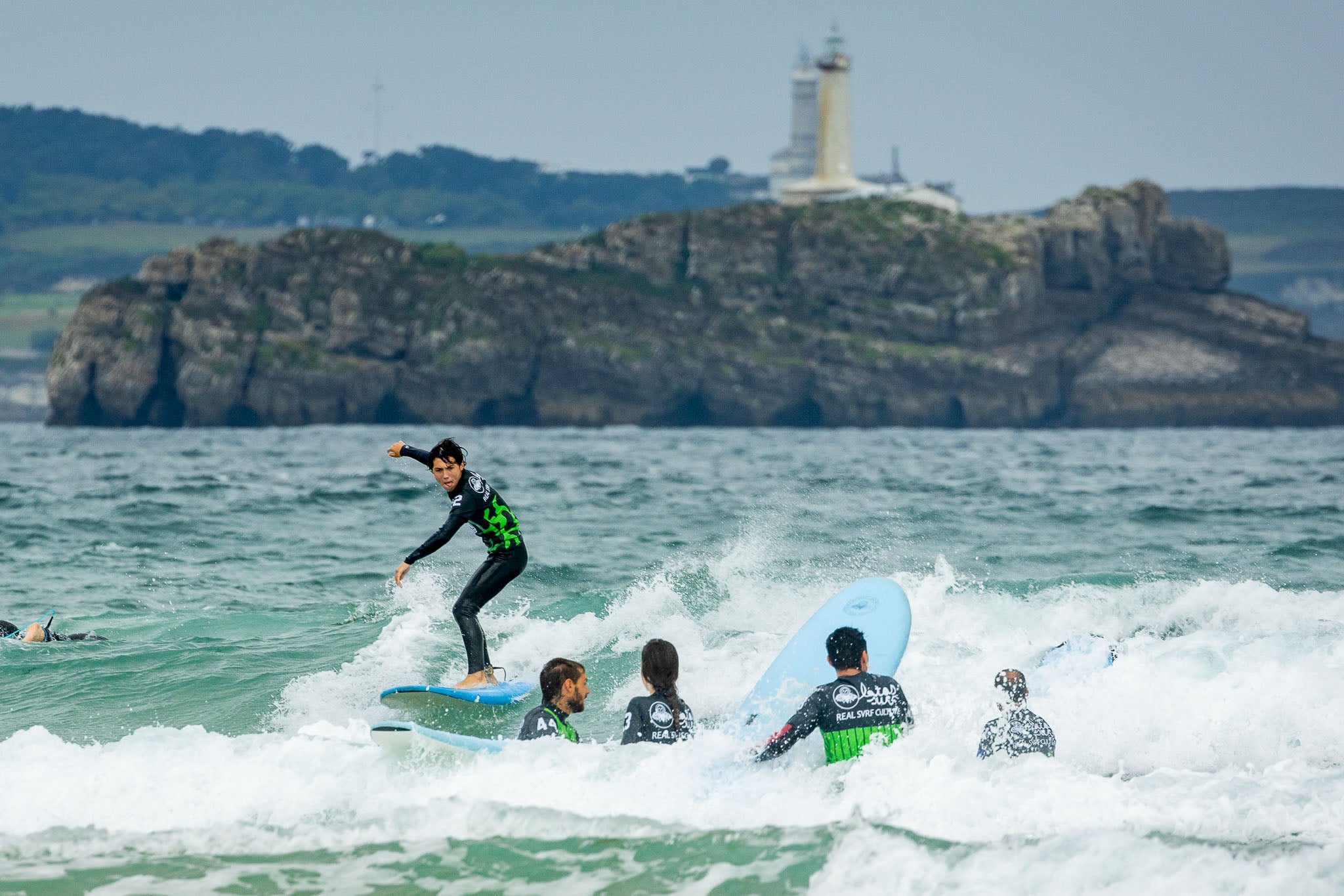 Uno de los alumnos más jóvenes se pone de pie en una ola.