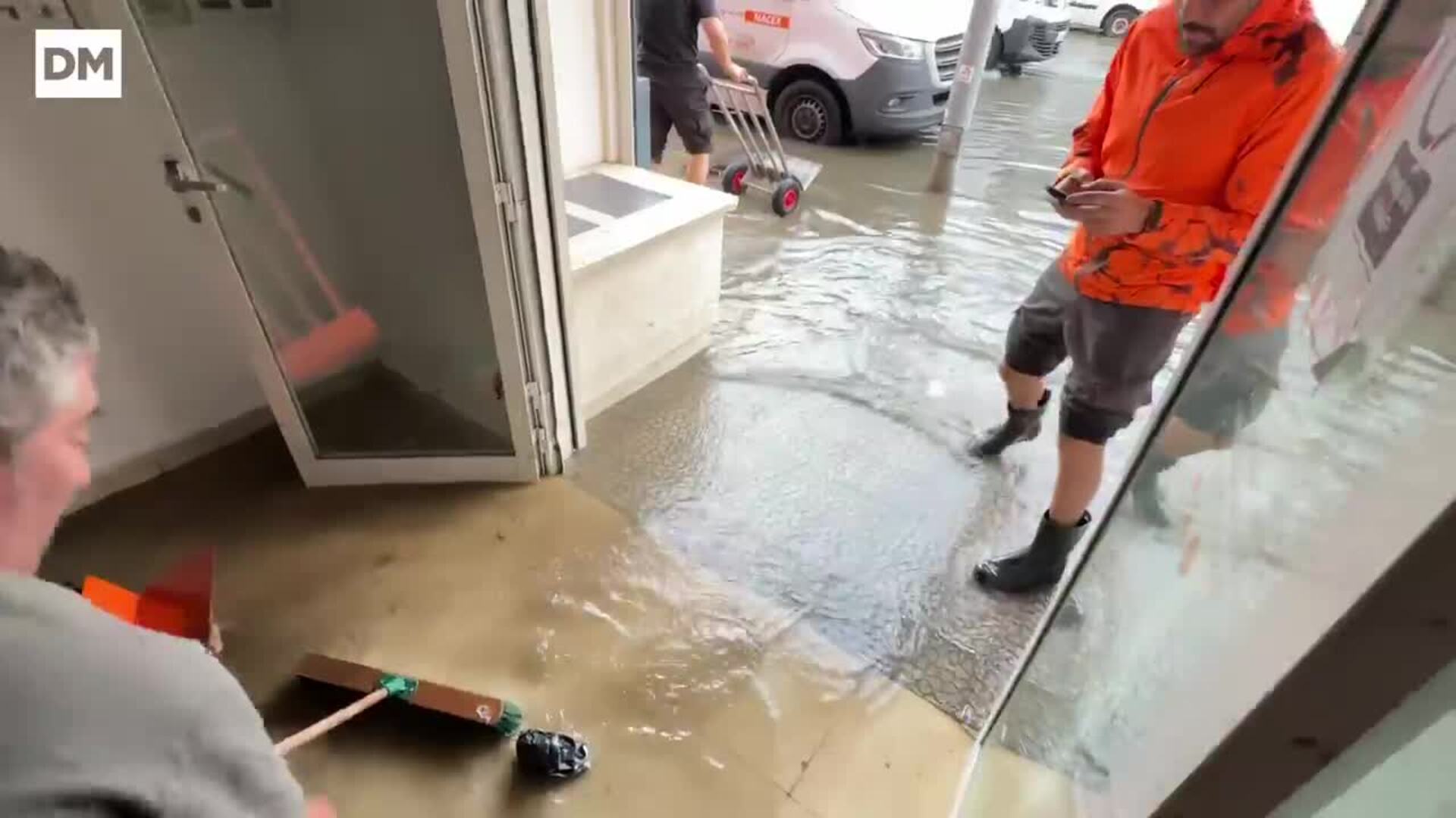 Ciudadanos achicando agua de las oficinas inundadas en Candina