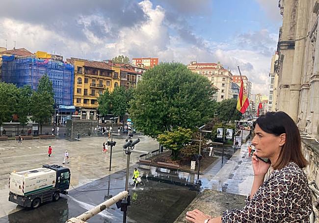 Gema Igual al teléfono en el balcón del Ayuntamiento esta mañana de jueves. En la plaza, la maquinaria limpiando