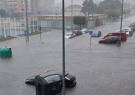 Enorme balsa de agua que cubre los coches en medio del aguacero, en la zona del Parque de Cros, en Maliaño.