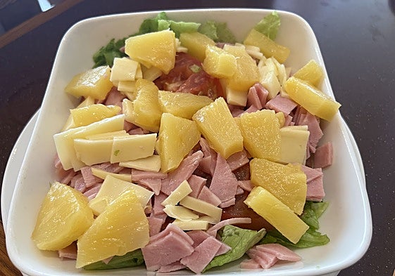 Ensalada tropical con lechuga, tomate, jamón york, queso y piña.