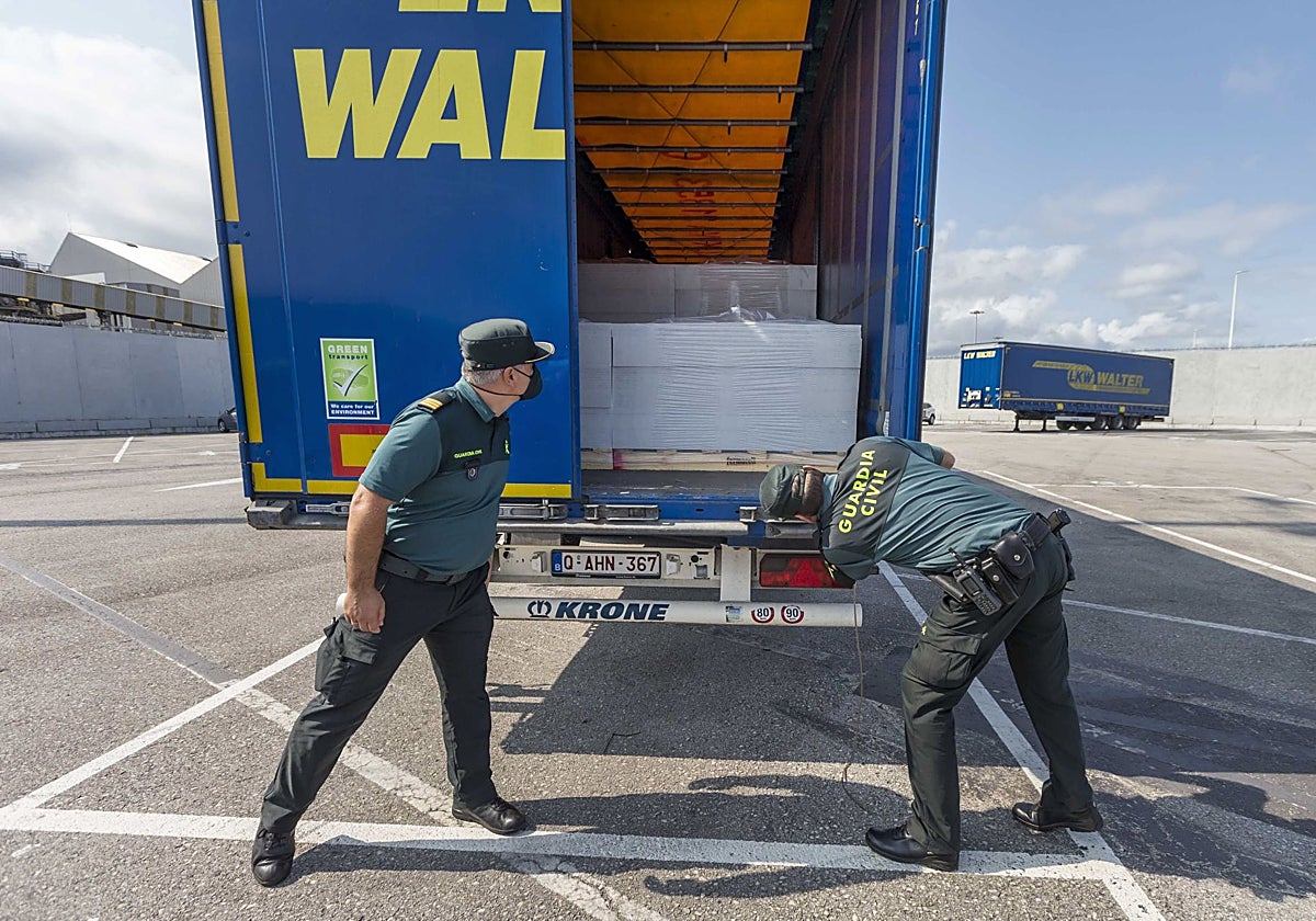 Dos agentes de la Guardia Civil revisan un camión en el Puerto de Santander.