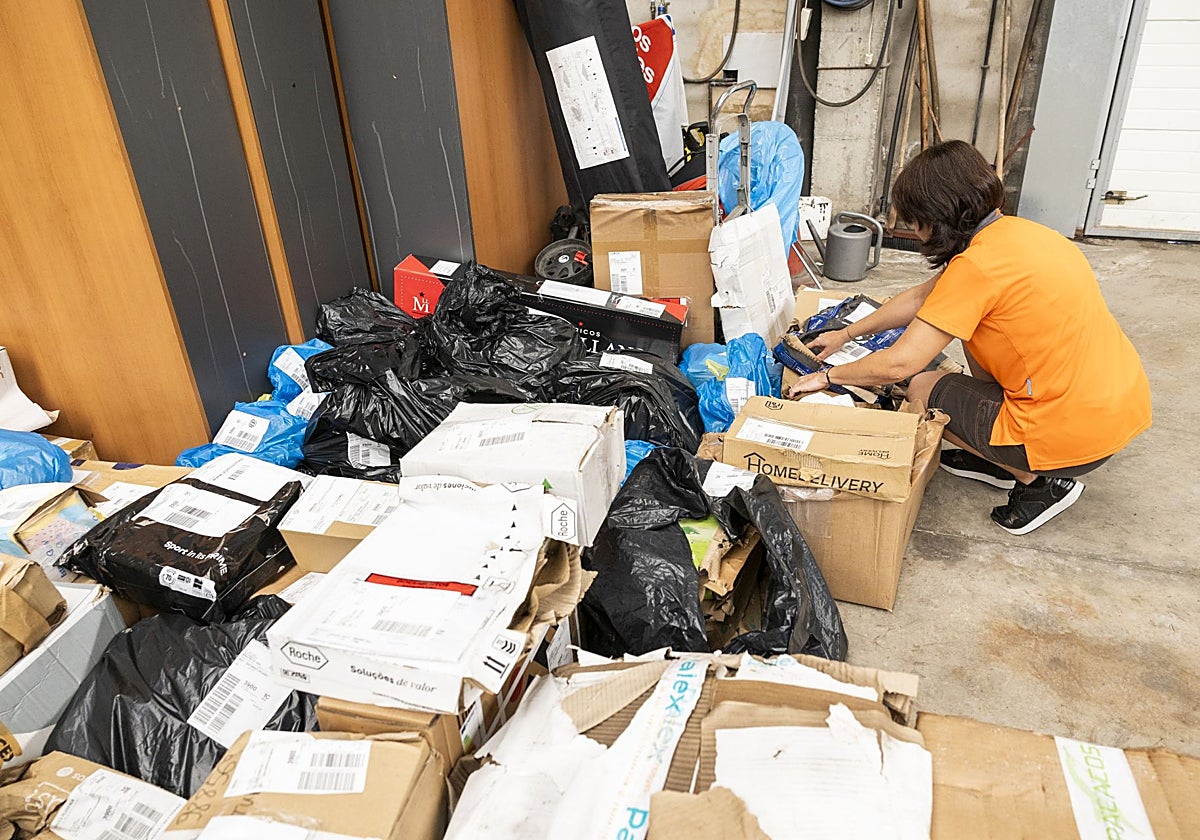 Una trabajadora de Nacex revisa los paquetes que se vieron afectados por el agua.