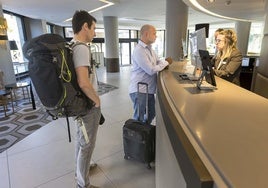 Unos turistas esperan en la recepción del Hotel Bahía de Santander.