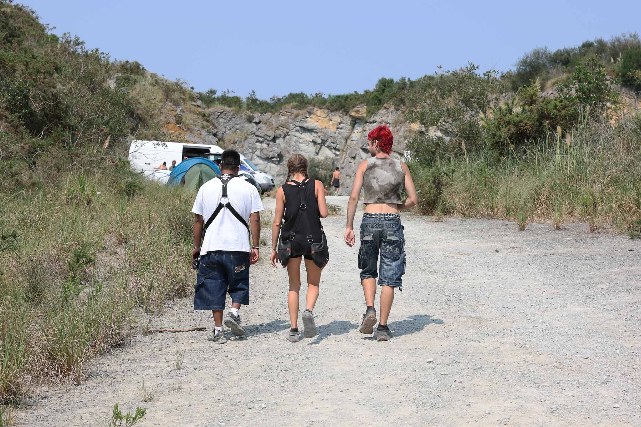 Tres jóvenes vuelven a sus vehículos. 