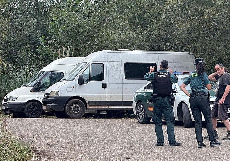 Dos guardias civiles, con uno de los asistentes a la rave, este lunes por la mañana.
