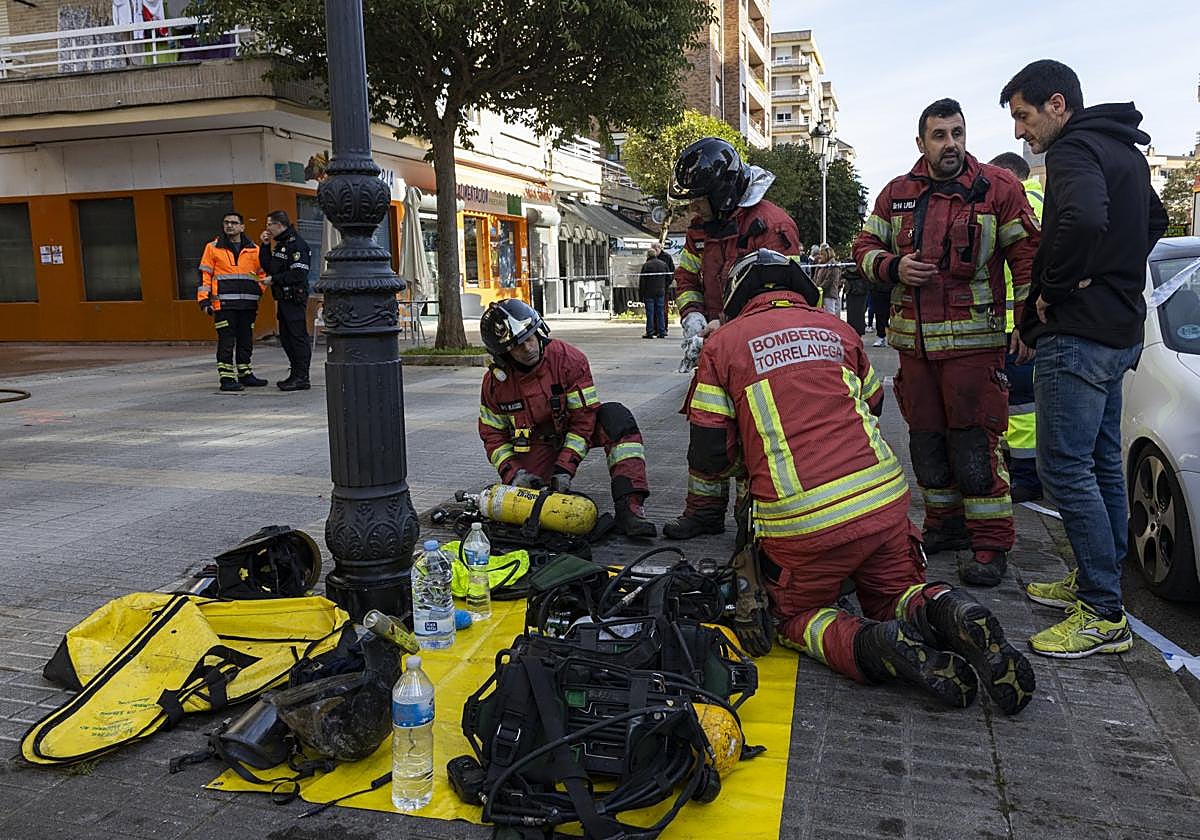 Efectivos del cuerpo de Bomberos de Torrelavega trabajan durante la extinción de un incendio en el Barrio Covadonga, en febrero.