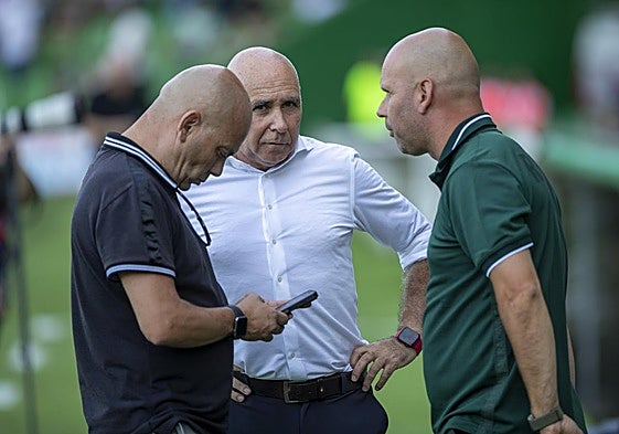 Chema Aragón ojea su móvil mientras conversa con Manolo Higuera y José Alberto López en los Campos de Sport.