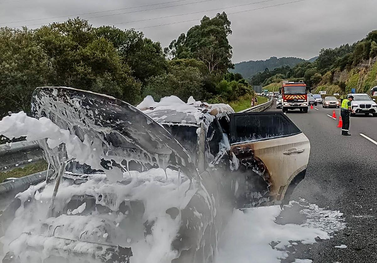 San Vicente de la Barquera: Vehículo calcinado en la autovía A-8, mientras las autoridades policiales regulan el tráfico.