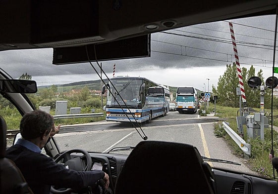 Un conductor de autocar espera para cruzar el paso a nivel de Reinosa.