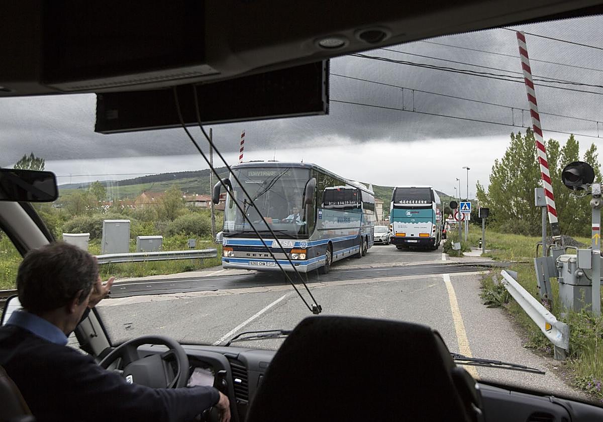 Un conductor de autocar espera para cruzar el paso a nivel de Reinosa.