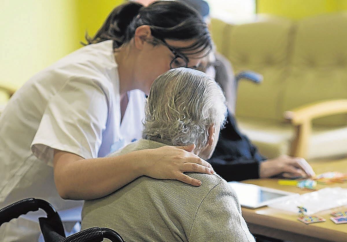 Una trabajadora atiende a una persona en la residencia, en una imagen de archivo.