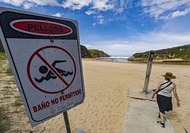 En la playa de Galizano un cartel indica la prohibición de bañarse por contaminación.