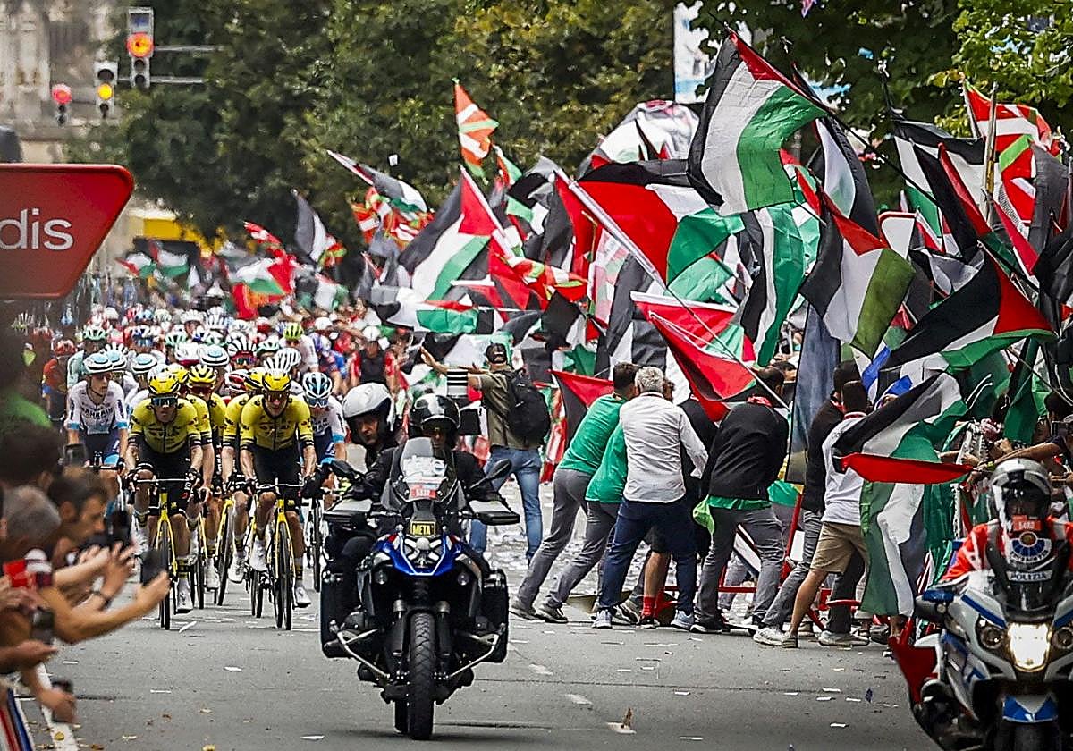 Un grupo de manifestantes en favor de Palestina y en contra de Israel invade la carretera al paso previo del pelotón por la meta situada en la Gran Vía de Bilbao.