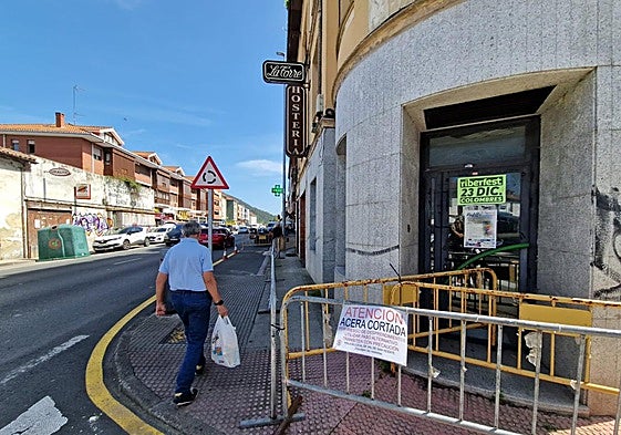 Un vecino pasa junto al hostal La Torre, vallado por el riesgo de desprendimiento.
