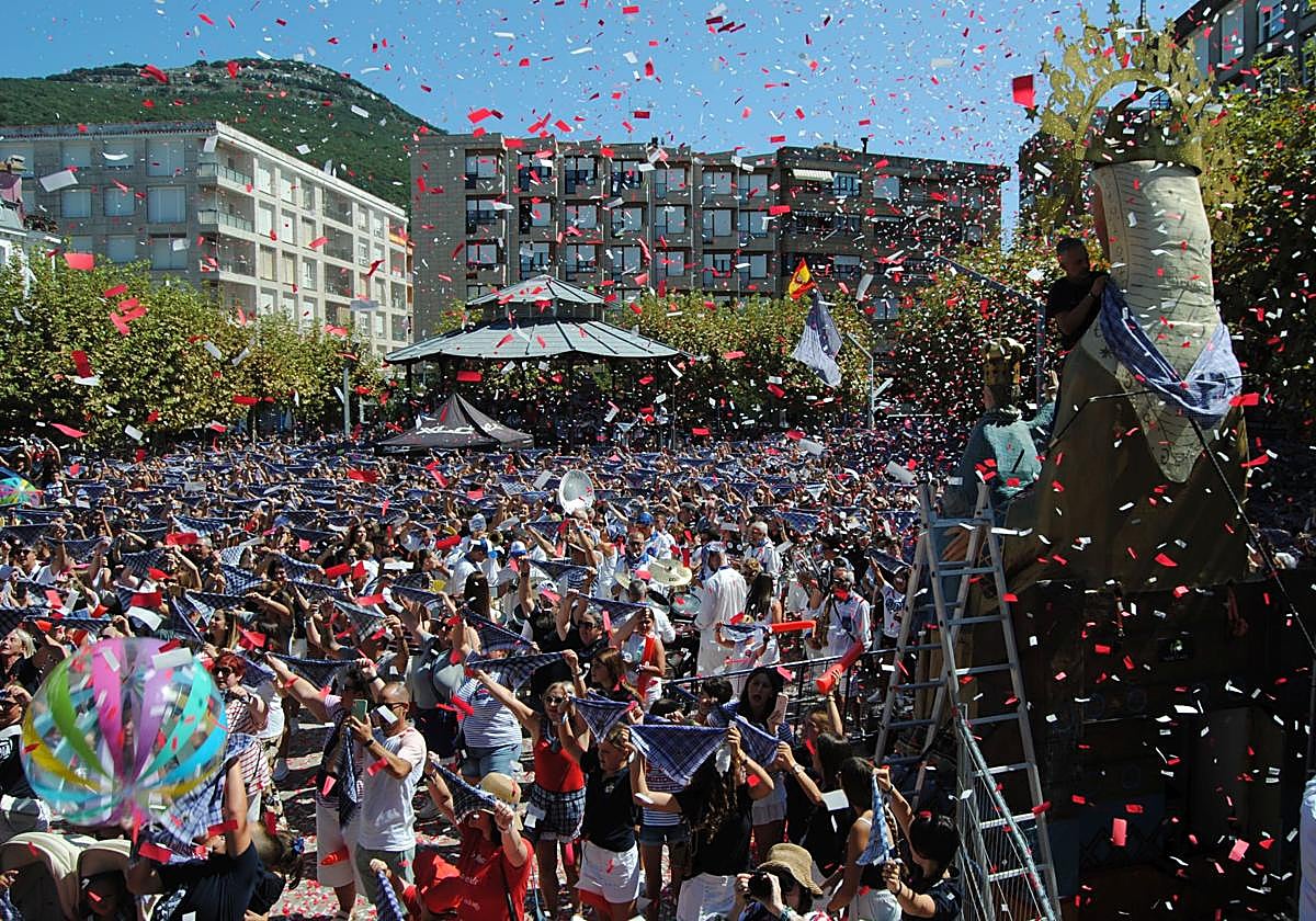 Multitud con el pañuelo marinero en alto cantando el himno de Santoña.
