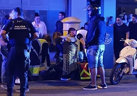 Personal sanitario atiende a la víctima en el lugar de los hechos, custodiados por agentes de la Policía Local, este viernes, en Torrelavega.