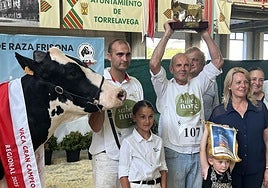 Fotografía: Adrián e Ivón Entrecanales, con sus hijas, la consejera María Jesús Susinos, y el alcalde de Valdáliga, Lorenzo González, posan con el trofeo de 'Vaca Gran Campeona' al que se hizo acredora Cudaña Arenetes Dallas| Vídeo: Ivón Entrecanales, de Ganadería Cudaña, la ganadora.