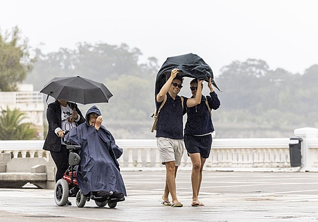 Juan Martín y Carolina Rodríguez se tapan de la lluvia con una chaqueta.