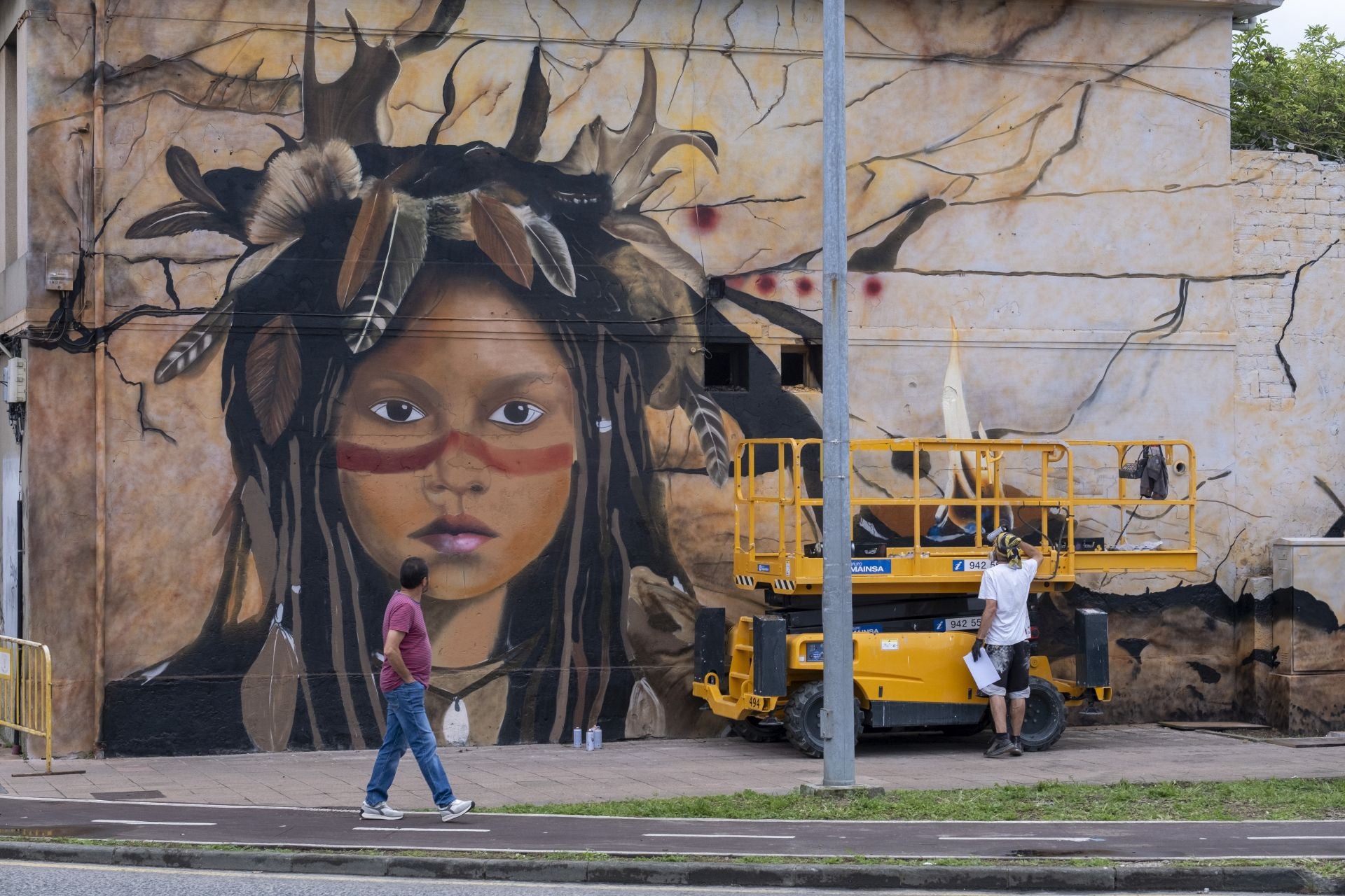 Un hombre pasea por delante de una de las fachadas que han sido pintadas dentro de la iniciativa.