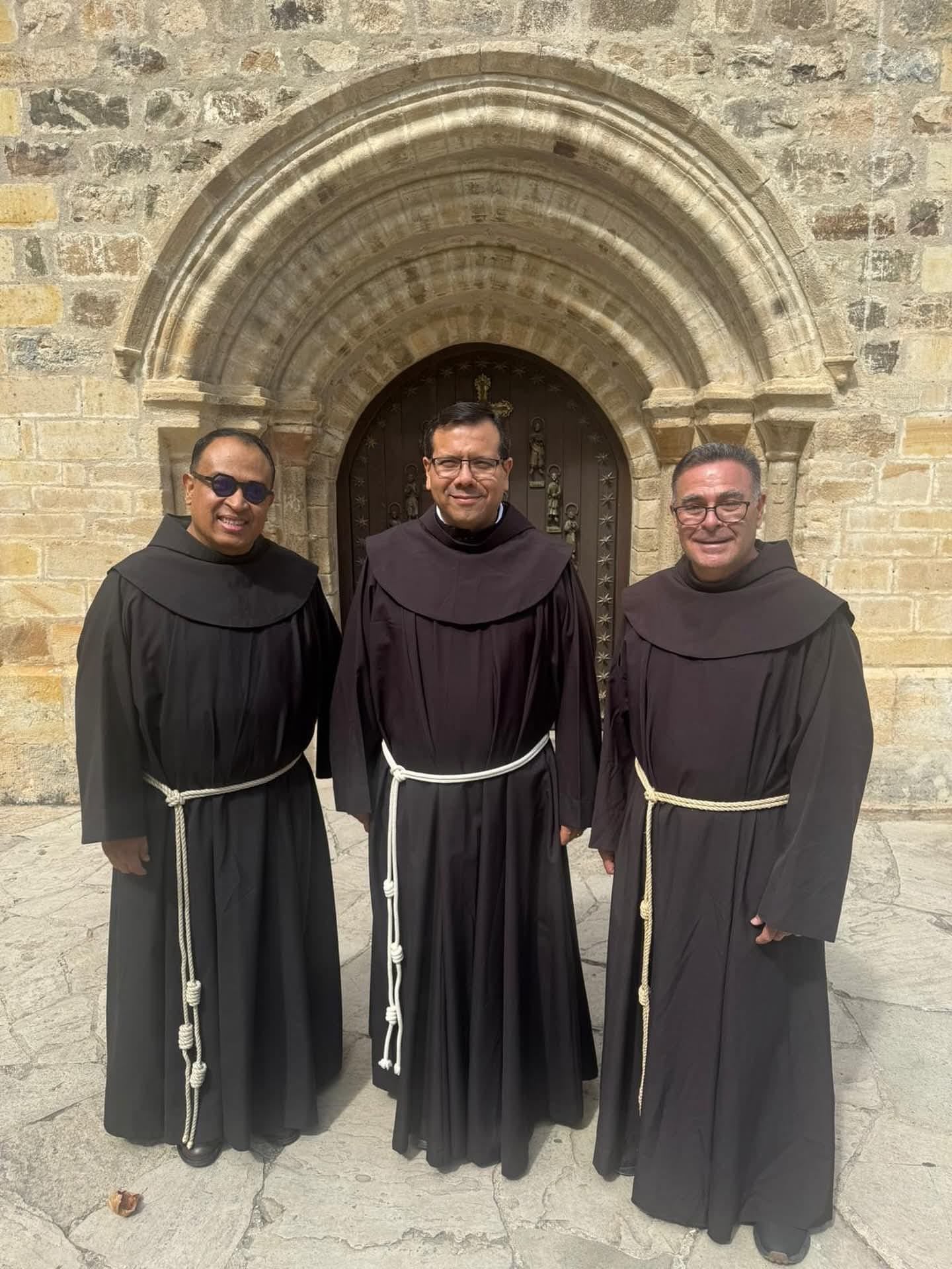 Los tres franciscanos mexicanos frente a la Puerta del Perdón del monasterio de Santo Toribio