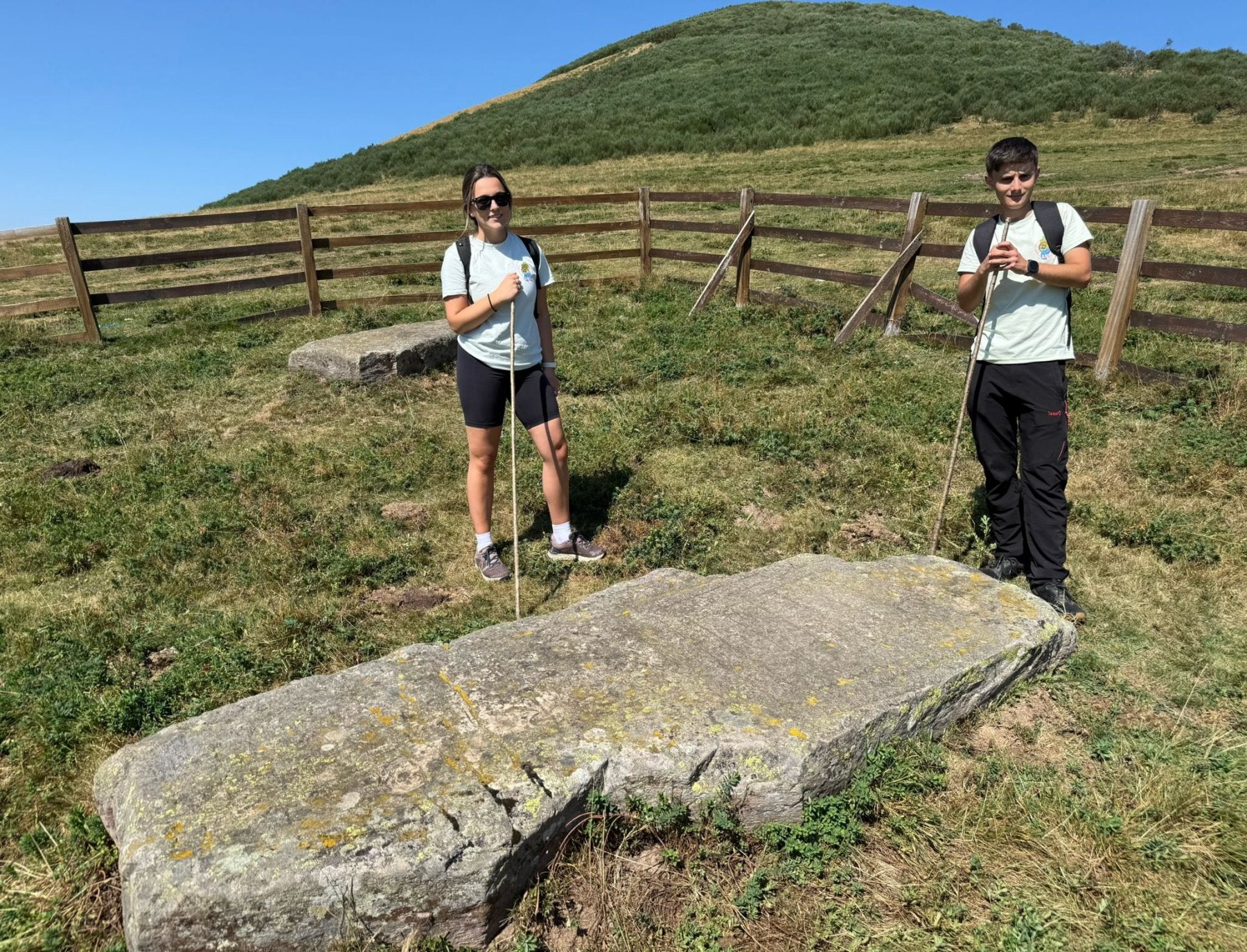 Paula García y Pablo Sotres, guías de la Mancomunidad del Nansa, ante uno de los menhires más interesantes de todo el conjunto.