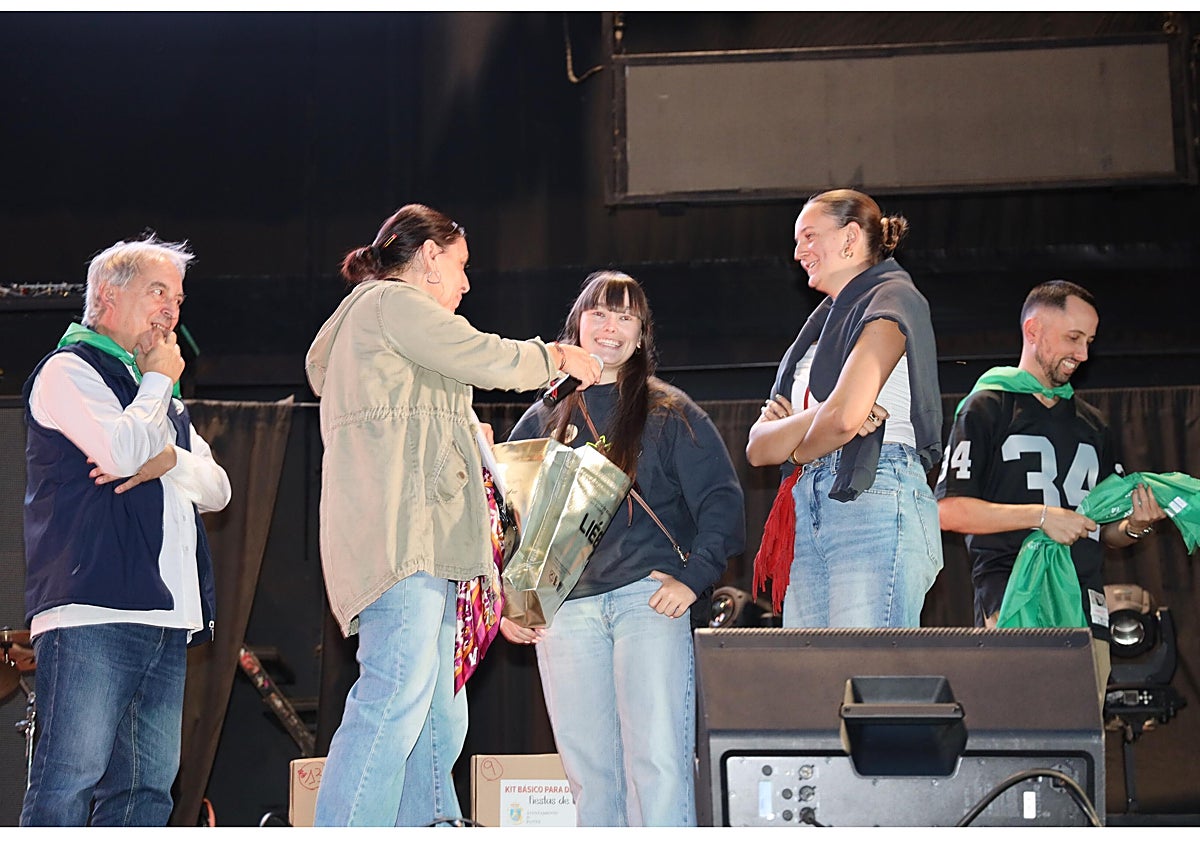 Imagen principal - Representantes de una de las peñas que subieron a recoger pañuelos y caja de regalo; el equipo de fútbol sala «Los Lebaniegos», ganador del torneo, e integrantes del grupo «Gran Reserva», durante su actuación en La Serna