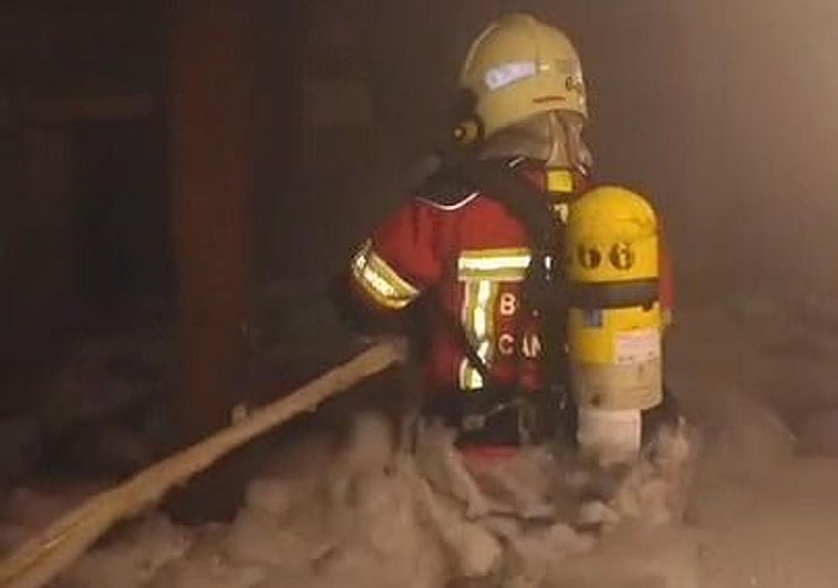 Uno de lo sbomberos comprueba los daños tras apagar el fuego.