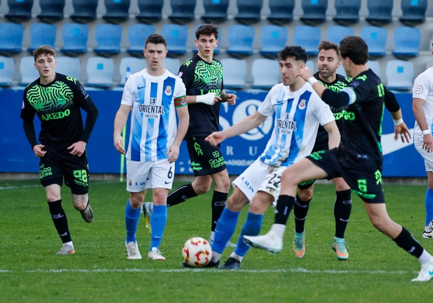 Santamaría, con el balón, rodeado de jugadores del Laredo.