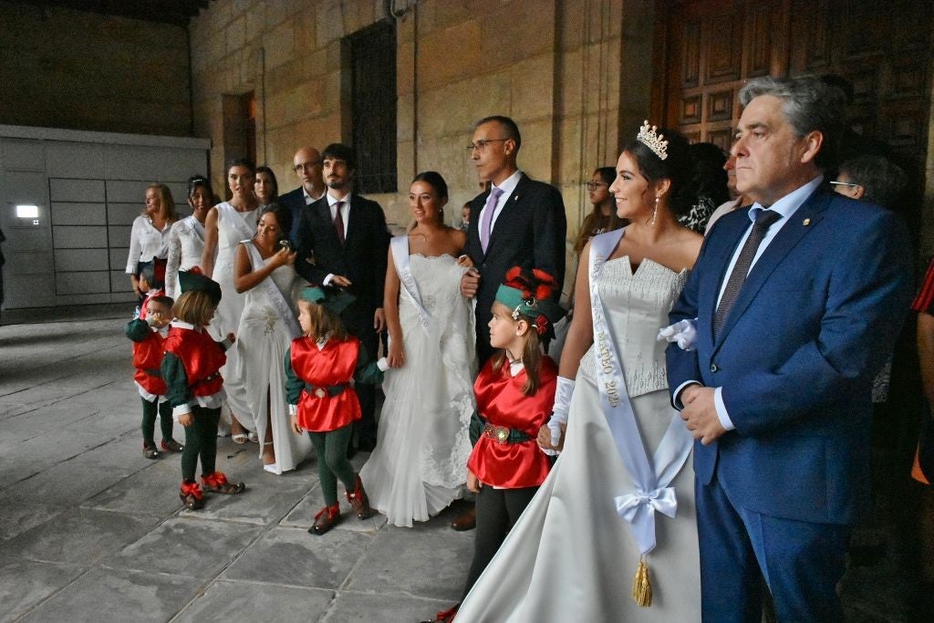 Corte de Honor y acompañantes en los soportales del Ayuntamiento escuchando a la banda de Reinosa.