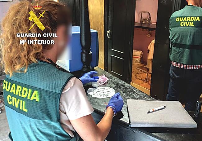 Una agente de la Guardia Civil requisa envoltorios con cocaína en la operación desarrollada en Heras.