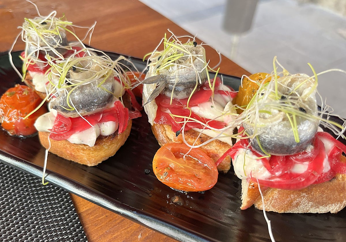 Imagen principal - Gávros marinátos (boquerones marinados con ajo y perejil, acompañados de hinojo y cebolla encurtida); moussáka griega con patata, berenjena, carne picada y bechamel; y manitária yemista (champiñones gratinados rellenos de queso graviera, embutido syglino y mayo casera de trufa).