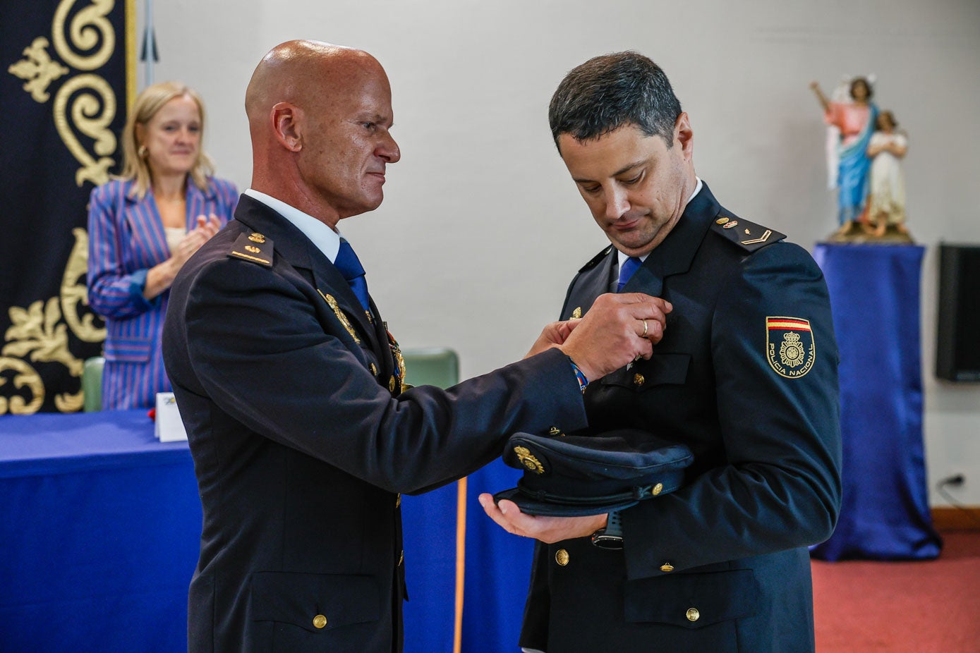 El jefe de la comisaría de Torrelavega, Fernando Chemelal, le entrega la la Cruz al Mérito Policial con distintivo blanco a un agente.