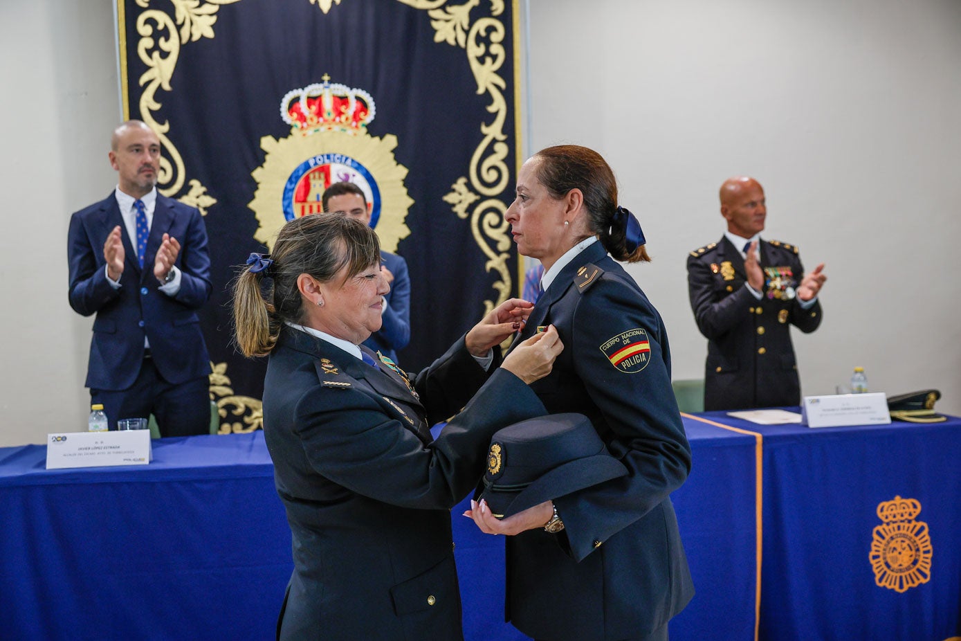 María del Carmen Martínez Ruiz le coloca la Medalla a una policía nacional.
